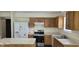 Functional kitchen with stainless steel appliances, wood cabinets, and white countertops, ready for cooking at 403 Bagley Ln, Indianapolis, IN 46231