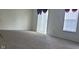 Spacious carpeted living room area filled with natural light from windows and glass door at 403 Bagley Ln, Indianapolis, IN 46231