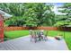 Inviting backyard featuring a wooden fence, lush lawn, and a deck with outdoor furniture and potted flowers at 4132 Tincher Rd, Indianapolis, IN 46221