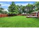 Well-maintained backyard featuring a lush lawn, wooden fence, fire pit, and a charming deck with patio furniture at 4132 Tincher Rd, Indianapolis, IN 46221