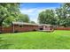Spacious backyard boasts a well-kept lawn, brick home, wooden fence, and a cozy deck with patio furniture at 4132 Tincher Rd, Indianapolis, IN 46221