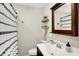 Well-lit bathroom features a classic vanity, decorative mirror, and a shower with a stylish black and white curtain at 4132 Tincher Rd, Indianapolis, IN 46221