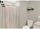 A simple bathroom with a toilet and shower, featuring neutral walls, and a shelf at 4132 Tincher Rd, Indianapolis, IN 46221