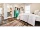 Bright bedroom with wood floors, green dresser, and access to the bathroom at 48 E Palmer St, Indianapolis, IN 46225