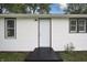 Back exterior featuring white siding with black trim around the door and windows at 523 Patterson Rd, Columbus, IN 47203