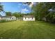 Wide shot of backyard including home and large trees at 523 Patterson Rd, Columbus, IN 47203