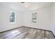 Bright bedroom with two windows and sleek gray wood floors at 523 Patterson Rd, Columbus, IN 47203