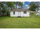 Charming home with a well-maintained lawn, lush trees, and covered parking at 523 Patterson Rd, Columbus, IN 47203
