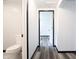 Bright hallway with gray wood floors and black trim that connects to a bathroom at 523 Patterson Rd, Columbus, IN 47203
