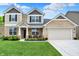 Beautiful two-story home with manicured lawn, stone accents, neutral siding, and covered front porch at 5306 Lavender Dr, Plainfield, IN 46168