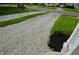 Gravel driveway is flanked by yard and mulched landscaping at 5430 E 17Th St, Indianapolis, IN 46218