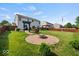 Beautiful backyard showcasing a brick fire pit, pergola swing, and green lawn at 5960 Dado Dr, Noblesville, IN 46062