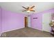 Bedroom with purple walls, ceiling fan, carpet flooring, and door to an adjacent room at 5960 Dado Dr, Noblesville, IN 46062