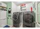 Well-lit laundry room with modern washer and dryer, white cabinets, and ample storage space at 5960 Dado Dr, Noblesville, IN 46062