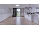 Bright living room features wood-look floors, neutral walls, and sliding glass door with backyard views at 5964 N Pr Wind Drift Ln, Shelbyville, IN 46176