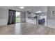 Open living room features modern wood-look floors, neutral walls, eat-in kitchen, and backyard access at 5964 N Pr Wind Drift Ln, Shelbyville, IN 46176