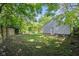 Backyard featuring a fenced yard with grass and a detached garage with a white door at 6029 English Ave, Indianapolis, IN 46219