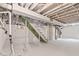 This basement features painted walls, ceilings, and support beams with stairs at 6029 English Ave, Indianapolis, IN 46219