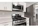 Updated kitchen showcasing stainless steel appliances and quartz countertops at 6029 English Ave, Indianapolis, IN 46219