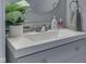 Close up of vanity with white countertop, modern faucet, and round mirror in bathroom at 6214 Weller Cir, Indianapolis, IN 46268