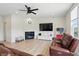 Cozy living room features a fireplace, ceiling fan, and a large television at 633 Cowley Dr, Westfield, IN 46074