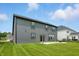 Exterior view of the home highlighting the backyard space with a patio, lawn and gray siding at 633 Cowley Dr, Westfield, IN 46074