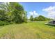 Backyard with well-maintained lawn, beautiful trees, and a privacy-enhancing tree line bordering the property at 6332 Card Blvd, Indianapolis, IN 46221