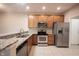 Modern kitchen featuring stainless steel appliances, granite countertops, and light wood cabinets at 6586 Quail Run, Fishers, IN 46038