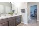 Bathroom with double sinks, marble countertop, brown cabinets, and a walk-in closet in the background at 6737 Trey Dr, Camby, IN 46113