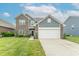 Charming two-story home with a brick and vinyl facade, landscaped yard, and attached two-car garage at 6737 Trey Dr, Camby, IN 46113