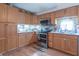 The kitchen boasts warm wood cabinets, stainless steel appliances, and attractive tiled backsplash at 6805 Jackson St, Indianapolis, IN 46241