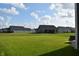 Spacious backyard featuring lush green grass and a view of neighboring homes under a blue sky at 7153 Sultans Run Ln, Whitestown, IN 46075