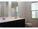 Bathroom with double sinks, a dark vanity, and a window with a view of the neighborhood at 7153 Sultans Run Ln, Whitestown, IN 46075