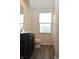 Bright bathroom featuring a dark vanity, wood-look floors, and a window for natural light at 7153 Sultans Run Ln, Whitestown, IN 46075
