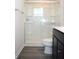 Modern bathroom with a sleek glass-enclosed shower, and a dark vanity with sink and toilet at 7153 Sultans Run Ln, Whitestown, IN 46075