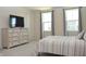 Comfortable bedroom with two large windows, a neutral-toned dresser, and a serene color scheme at 7153 Sultans Run Ln, Whitestown, IN 46075