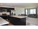 The well-lit kitchen flows into an open floorplan with black cabinetry and stainless steel appliances at 7153 Sultans Run Ln, Whitestown, IN 46075