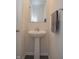 Simple powder room featuring a pedestal sink, mirror, and a neutral color palette at 7153 Sultans Run Ln, Whitestown, IN 46075