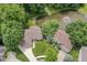 Aerial view of two homes surrounded by mature trees, featuring well-manicured lawns and a serene pond at 7175 Scarlet Oak Dr, Noblesville, IN 46062