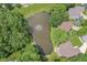 Aerial view of houses with a pond and fountain, surrounded by lush greenery, in a serene neighborhood at 7175 Scarlet Oak Dr, Noblesville, IN 46062