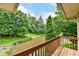 View from a wood balcony showcasing a tranquil backyard and a small pond surrounded by mature trees at 7175 Scarlet Oak Dr, Noblesville, IN 46062