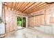 Unfinished basement featuring exposed ceiling, walk-out sliding door, and wood paneled walls at 7175 Scarlet Oak Dr, Noblesville, IN 46062