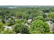 An aerial perspective shows a home surrounded by dense woods with a pool at 7629 Candlewood Ln, Indianapolis, IN 46250