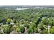 Aerial view showcases a charming neighborhood enveloped by lush trees and a serene lake at 7629 Candlewood Ln, Indianapolis, IN 46250