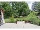 Spacious backyard with a concrete patio leading to a well-maintained lawn, surrounded by mature trees at 7629 Candlewood Ln, Indianapolis, IN 46250