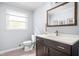 Modern bathroom with dark wood vanity, white countertop, and natural light at 7629 Candlewood Ln, Indianapolis, IN 46250