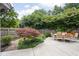 Backyard patio with a dining table, garden, and lush, mature landscaping surrounded by a wooden fence at 7629 Candlewood Ln, Indianapolis, IN 46250