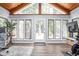 Bright sunroom with a vaulted ceiling, large windows, and a door to the yard at 7629 Candlewood Ln, Indianapolis, IN 46250