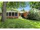 Charming brick home with a screened porch and mature trees in a lush backyard at 7736 Wawasee Dr, Indianapolis, IN 46250