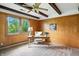 Cozy bedroom with wood paneled walls, a ceiling fan, and bright natural light from large windows at 7736 Wawasee Dr, Indianapolis, IN 46250